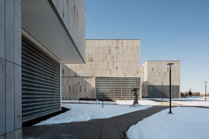 Arquitectura contemporánea en Pensilvania con volúmenes de piedra arenisca y celosías metálicas en museo universitario.