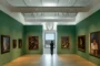 Galería de arte en museo de Pensilvania con paredes verdes y ventanal al paisaje.